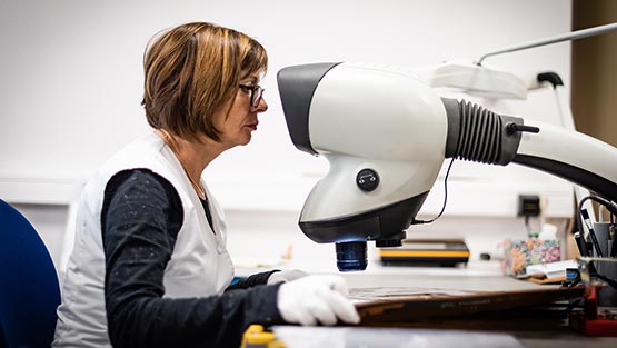 Un femme vérifiant la qualité d'un circuit imprimé flex électroniquement